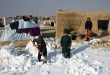 Afghan internally-displaced children shovel snow near their tents during a cold winter day at Nahr-e Shah-e- district of Balkh Province, near Mazar-i-Sharif on January 17, 2023. (Photo by Atif ARYAN / AFP)